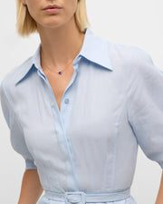 Woman in pale blue linen shirtdress wearing 18K gold vermeil lapis lazuli heart pendant necklace by Jan Leslie