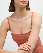 Model in rust orange dress wearing pink mother-of-pearl heart pendant necklace— Jan Leslie