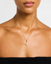  Woman wearing 18K gold vermeil white mother-of-pearl petal Seed of Life delicate drop pendant necklace close-up view