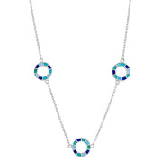 Sterling silver three-station necklace with open circle pendants featuring segmented navy, teal, and sky blue enamel mosaic detail.