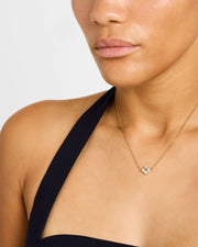 Model in black halter dress wearing white mother-of-pearl quatrefoil gold pendant necklace — Jan Leslie