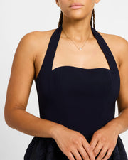 Model in black halter dress wearing white mother-of-pearl quatrefoil gold pendant necklace — Jan Leslie
