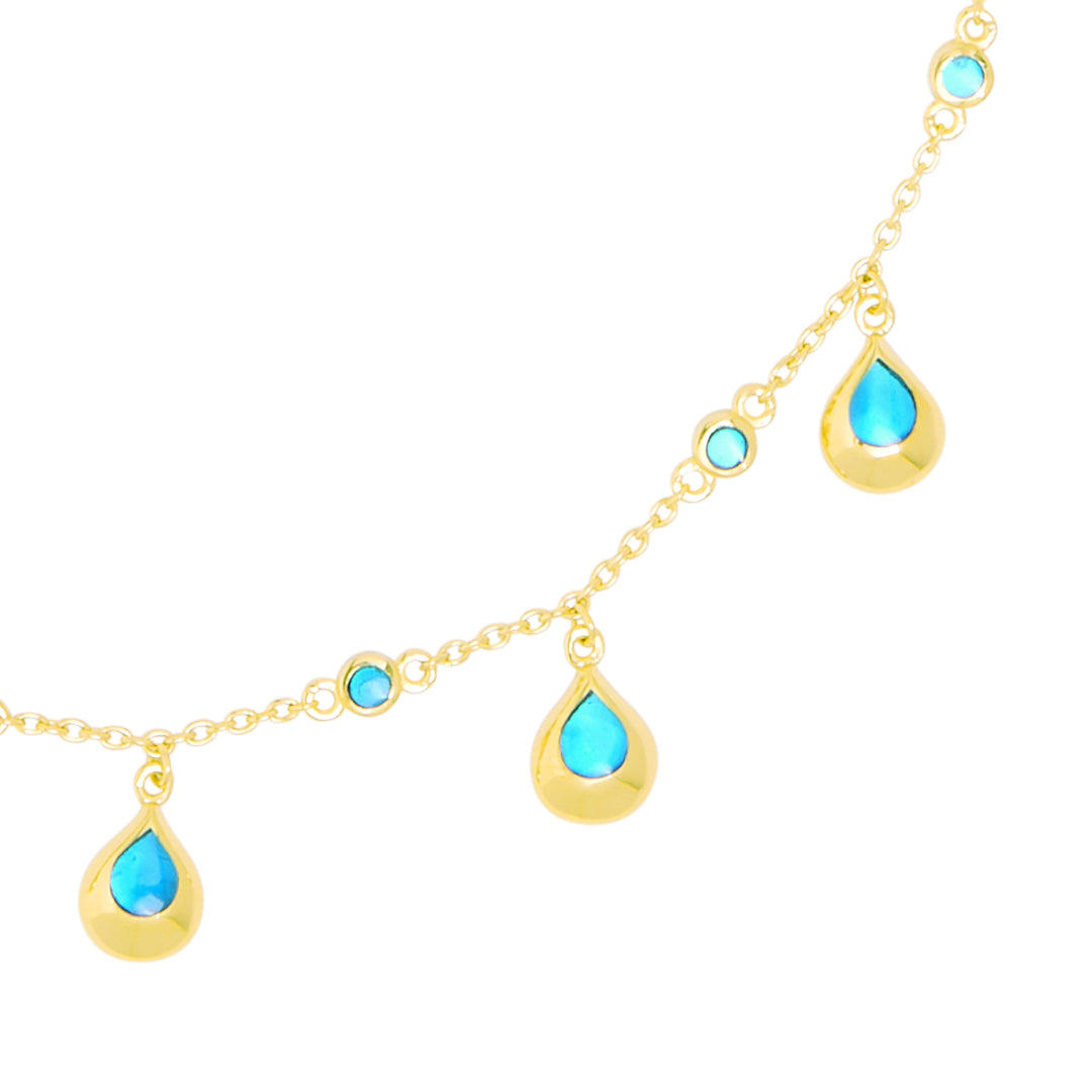 Gold chain necklace with vibrant turquoise teardrop charms and bezel-set stone stations 