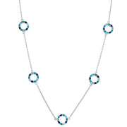 Sterling silver long station necklace with five open circle pendants featuring segmented blue and teal enamel mosaic detail.