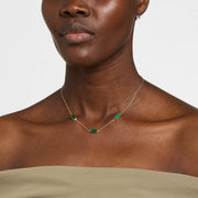Woman wearing gold vermeil sterling silver three-station malachite rectangle choker necklace at collarbone length over olive strapless top, showing banded green stone bezel settings, Jan Leslie luxury women's fine jewelry lifestyle.