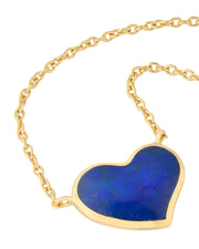 Gold cable chain necklace with a large heart-shaped pendant featuring deep blue lapis lazuli stone in a polished gold bezel setting.