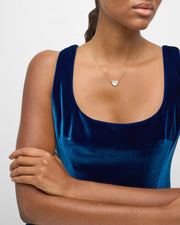 Model wearing gold vermeil white mother-of-pearl heart pendant necklace on delicate cable chain with blue velvet dress by Jan Leslie.