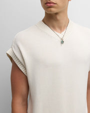  Man wearing oxidized sterling silver box chain necklace with malachite leaf abalone surfboard and feather charm cluster with cream knit vest by Jan Leslie.