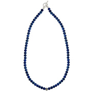 Overhead flat lay of matte lapis lazuli round bead necklace with oxidized sterling silver filigree accent bead centered on strand and sterling silver toggle clasp, Jan Leslie