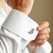 Man wearing 3D green and pink enamel rainbow trout cufflink on white French cuff, close-up wrist detail, luxury novelty men's fine jewelry lifestyle.
