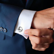 Sterling silver classic knot cufflink being fastened on white French cuff