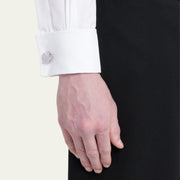 Man wearing sterling silver raw amethyst stalactite geode cufflink on white French cuff with black tuxedo jacket, wrist profile view, luxury men's fine jewelry lifestyle.