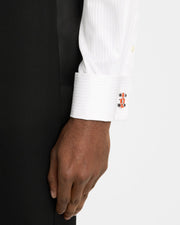 Man in black tuxedo jacket and white pleated bib dress shirt wearing sterling silver and orange enamel Formula 1 racing car cufflink on cuff, Jan Leslie