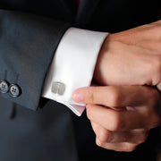 Cushion square brushed sterling silver cufflink worn on white French cuff with dark charcoal suit jacket