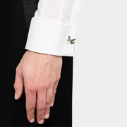 Man wearing sterling silver and gold dove of peace pearl body cufflink on white French cuff with black tuxedo jacket close-up by Jan Leslie