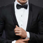an in black tuxedo jacket white pleated bib tuxedo shirt and black satin bow tie wearing Jan Leslie sterling silver black onyx tuxedo shirt studs