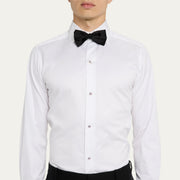 Man in white pleated tuxedo shirt and black bow tie wearing American flag enamel tuxedo studs down the placket.