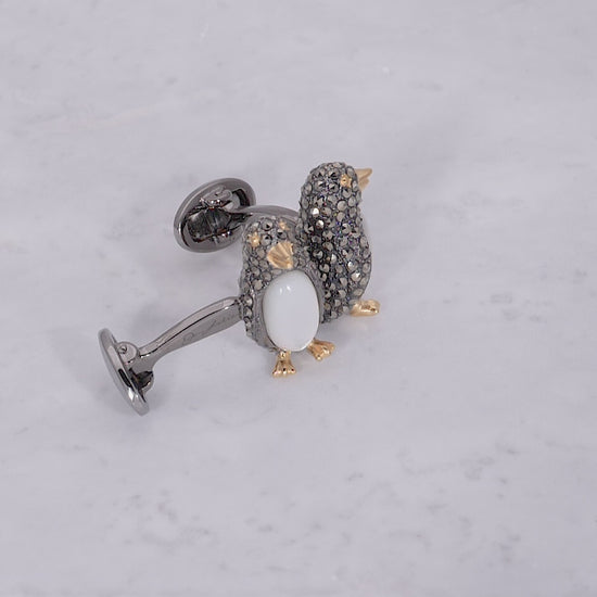 Video of 180 degree view of Jan Leslie's Gemstone Penguin with Marcasite, Mother of Pearl & Sterling Silver Cufflinks on marble background. 