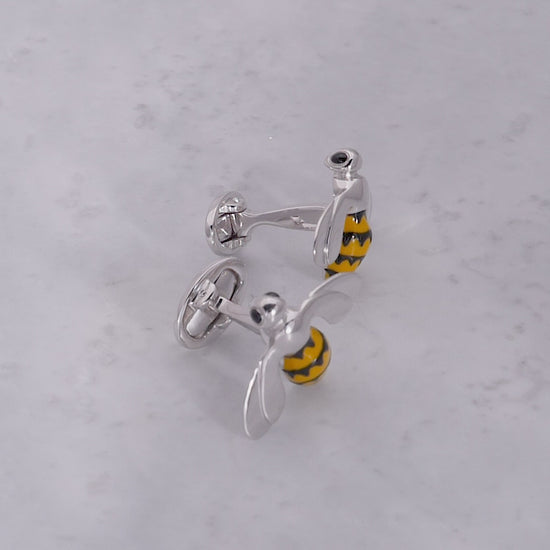 180 video of the Triumphant Bee Sterling Silver Cufflinks on a grey marbled background. 