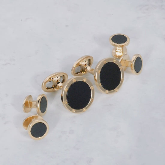 180 view of the Onyx Gemstone with Rivet Etch Details 18K Yellow Gold Cufflinks & Tuxedo Studs Set on a marble background. 