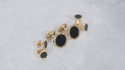 180 view of the Onyx Gemstone with Rivet Etch Details 18K Yellow Gold Cufflinks & Tuxedo Studs Set on a marble background. 