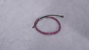 360 video of the an Leslie Faceted Ruby Gemstone Bracelet with Black Pull Cord on marble background. 