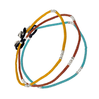 Group shot of Jan Leslie's Stackable Micro Bead Sterling Silver Bracelets in orange, red, and green. 