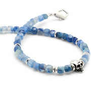 Close up of  the faceted kyanite, sterling silver skull, and spacer beads on the Faceted Kyanite Gemstone Skull Beaded Bracelet. 