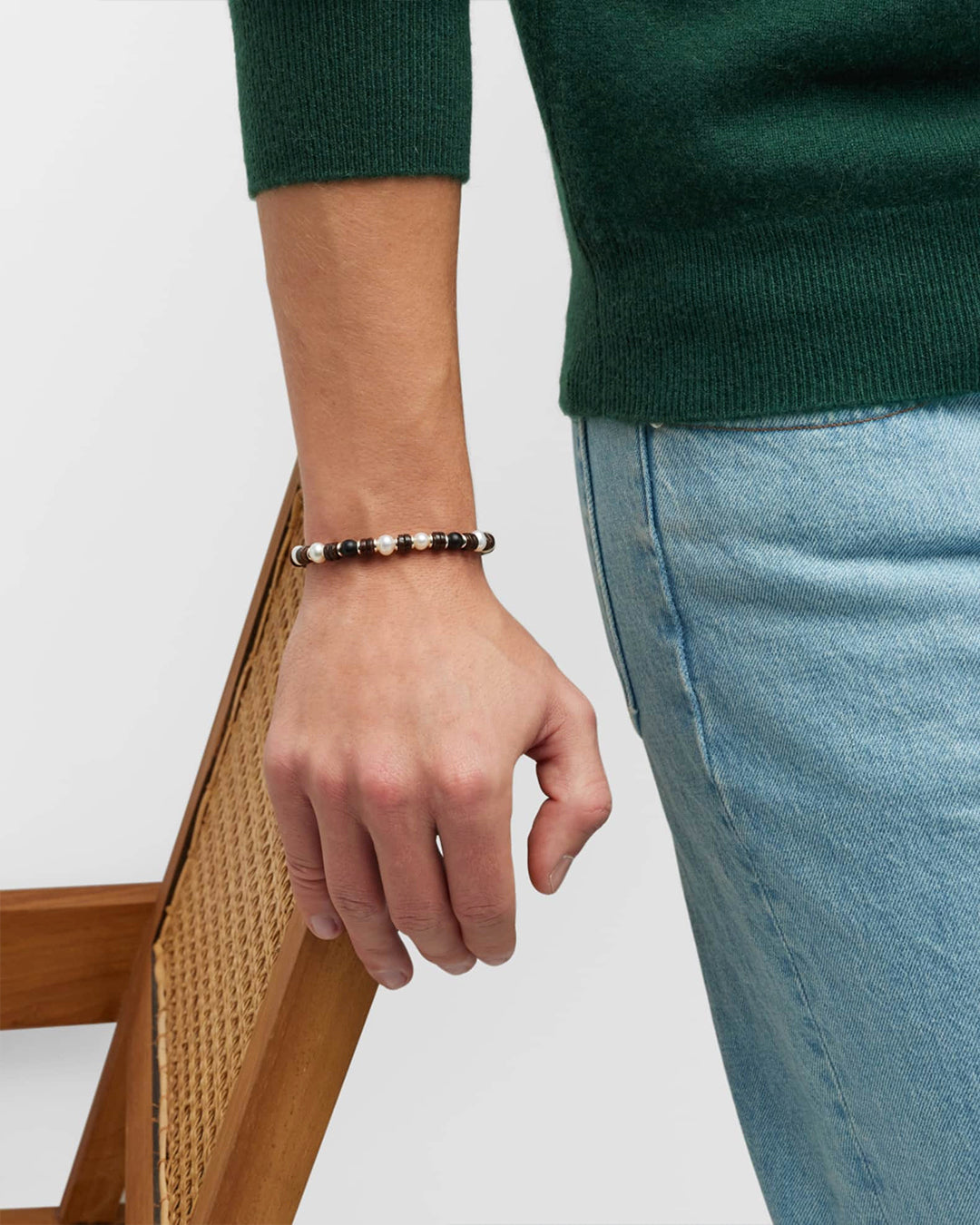 Picture of male models wrist wearing the Freshwater Pearl and Black Agate Beaded Bracelet. 