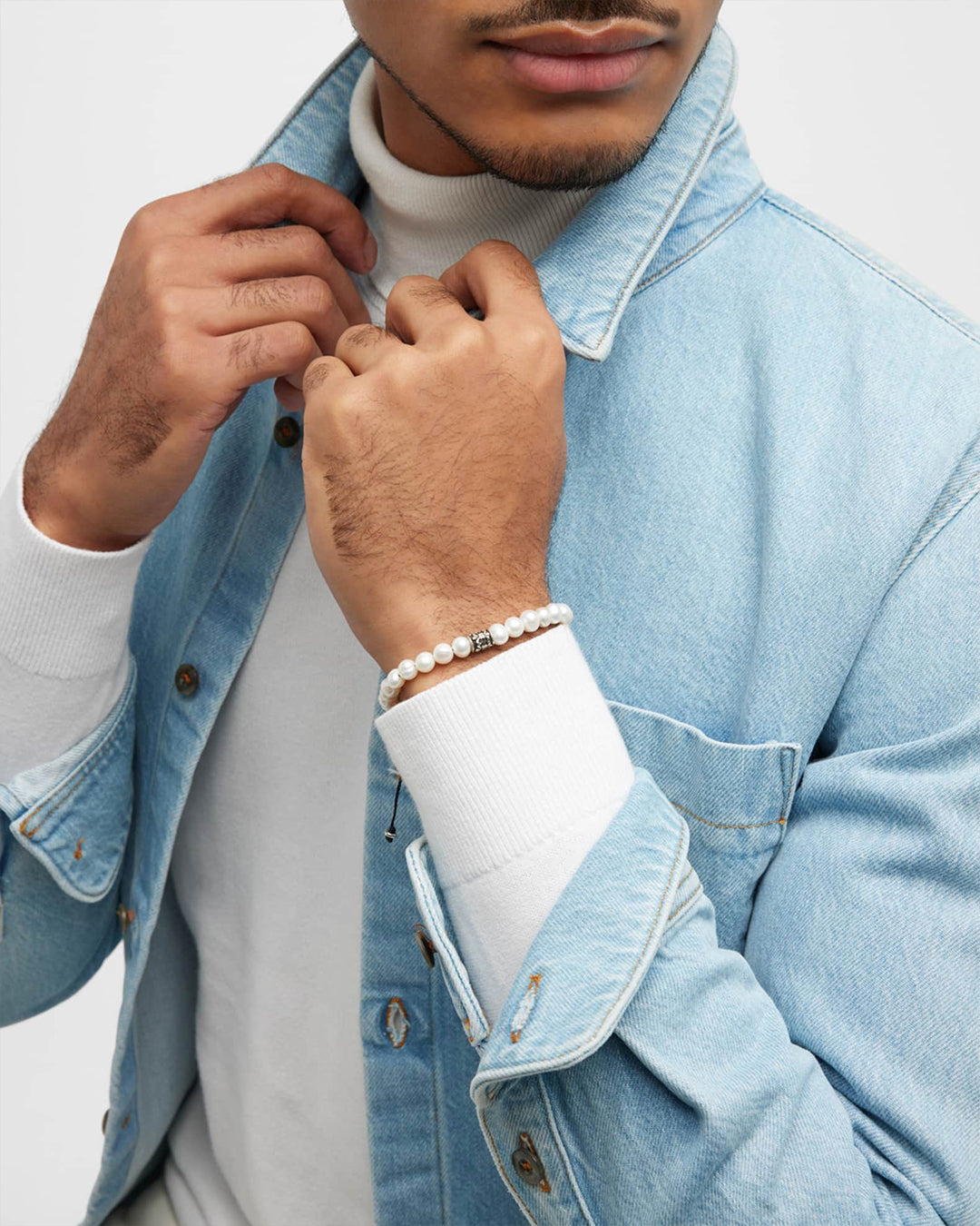 Male model wearing the Men's Freshwater Pearl Bracelet with Filigree Spacer. 