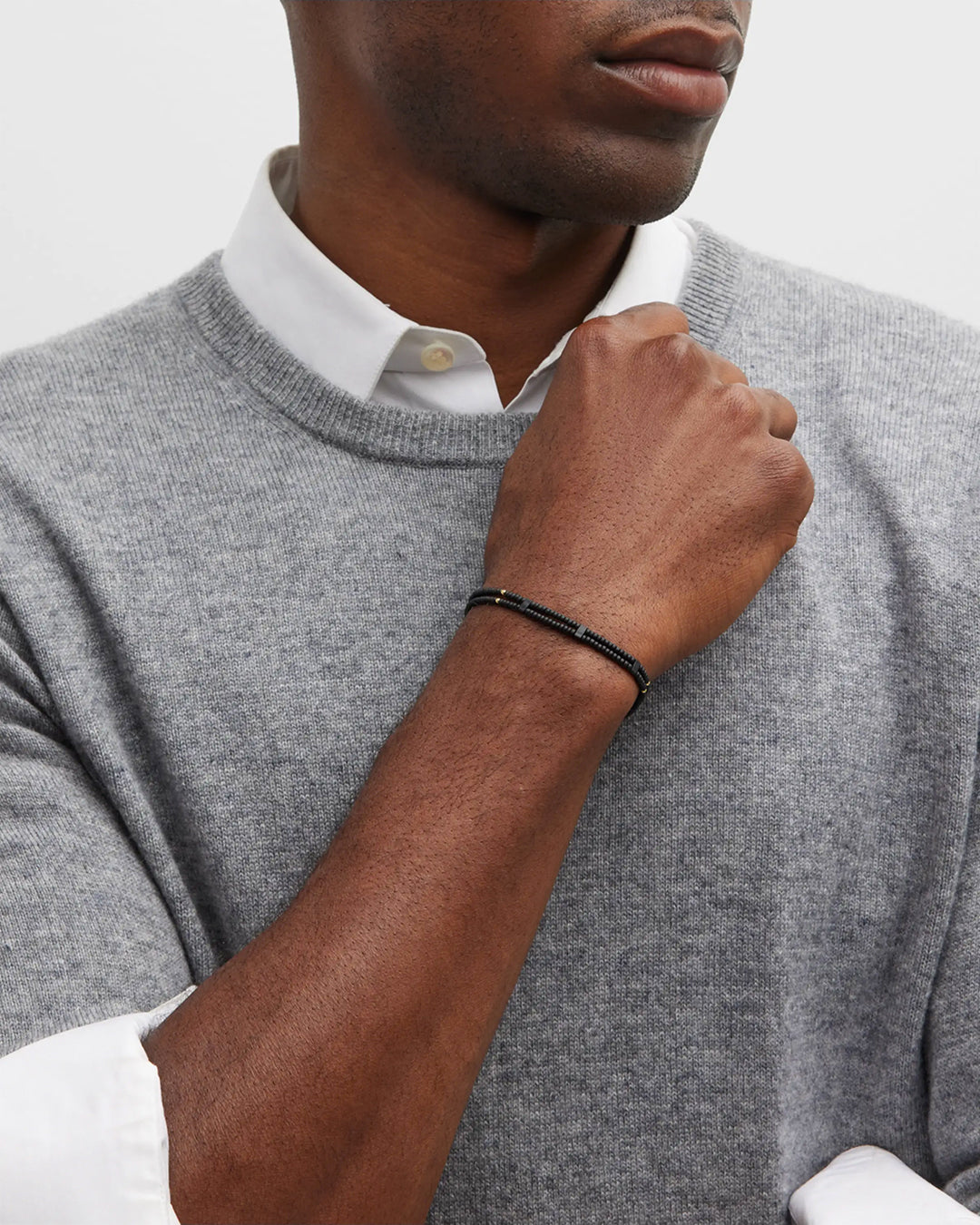 Close up of male model's wrist donning the Double Strand Black Micro Bead Wax Pull Cord Sterling Silver Bracelet. 