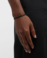 Close up of male models wrist showing off Double Strand Black Micro Bead Wax Pull Cord Sterling Silver Bracelet. 