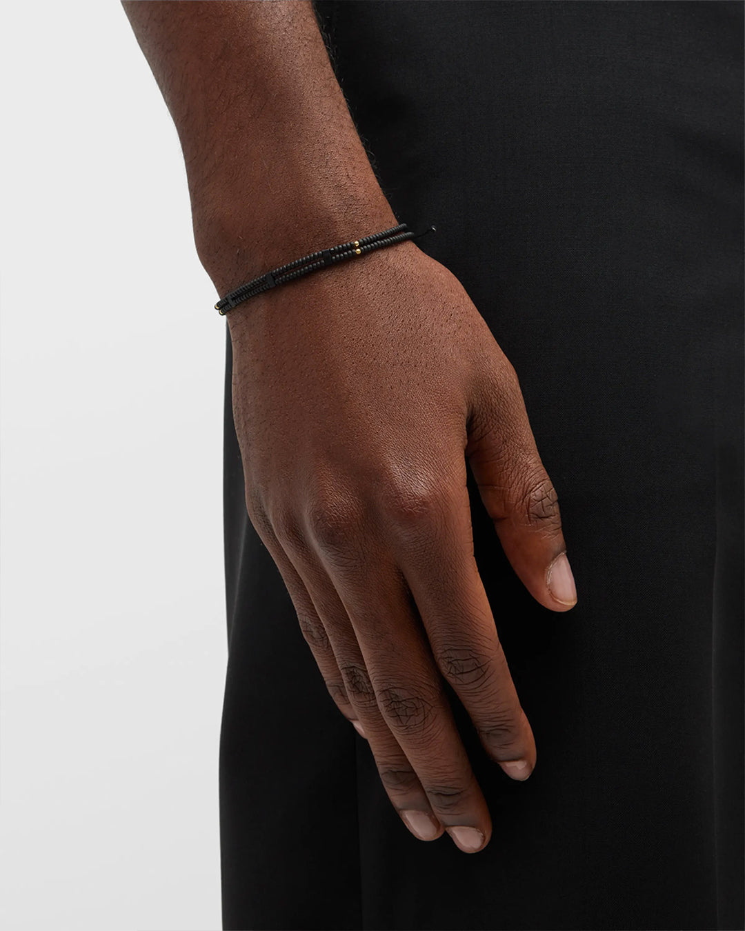 Close up of male models wrist showing off Double Strand Black Micro Bead Wax Pull Cord Sterling Silver Bracelet. 