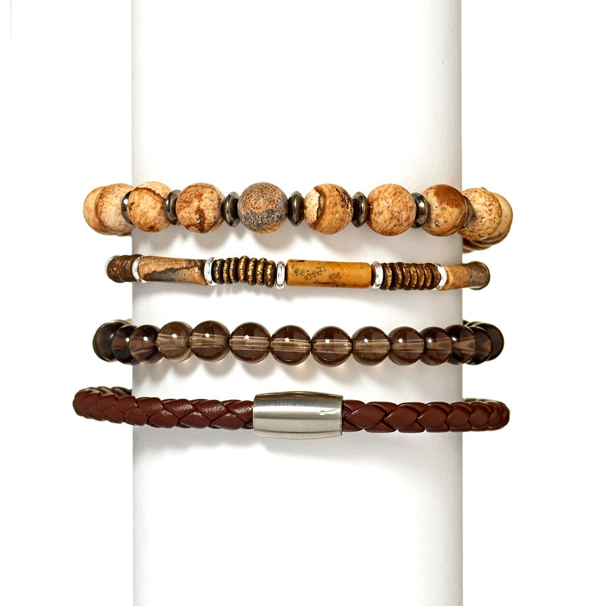 Jan Leslie bracelet stack on white bracelet holder: From top to bottom: Gemstone Bead Bracelet with Alternating Accent Breads, Cylinder Gemstone Bead Bracelet, 6MM Semiprecious Gemstone Beaded Elastic Bracelet, and Jan Leslie Magnetic-5 Braid Brown. 