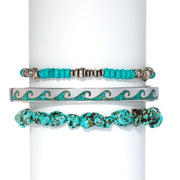 Three-piece turquoise bracelet stack with turquoise seed bead and oxidized silver disc spacer stretch bracelet polished sterling silver wave cuff with crushed turquoise mosaic inlay and raw turquoise nugget stretch bracelet