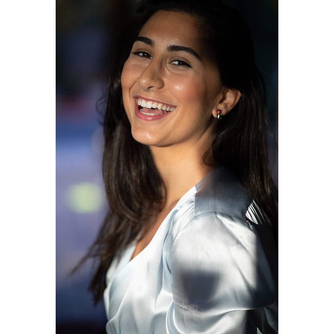 Laughing model wearing Jan Leslie's Rainbow Enamel Gummy Bear Stud Sterling Silver Earrings. 
