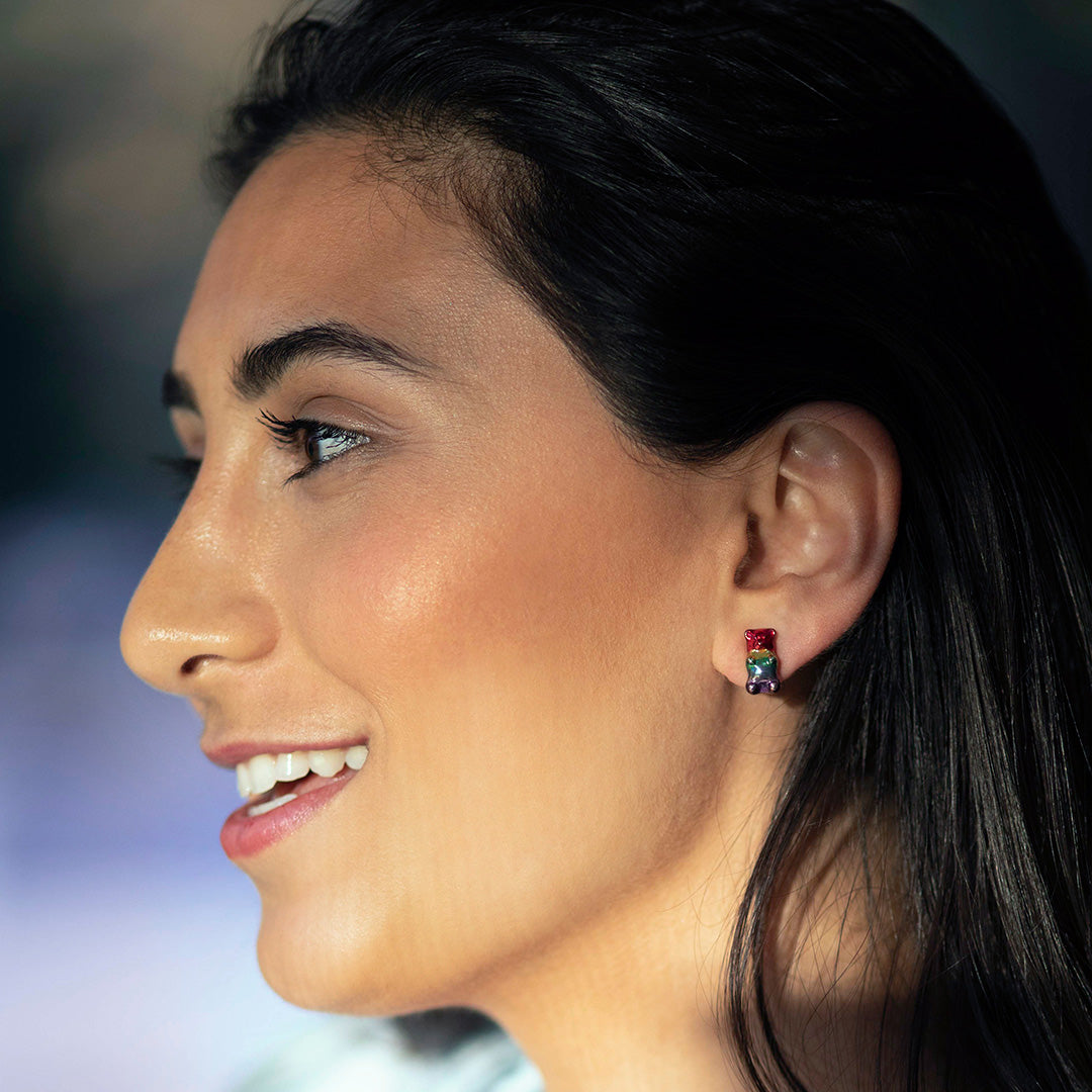 Smiling model wearing Jan Leslie's Rainbow Enamel Gummy Bear Stud Sterling Silver Earrings. 
