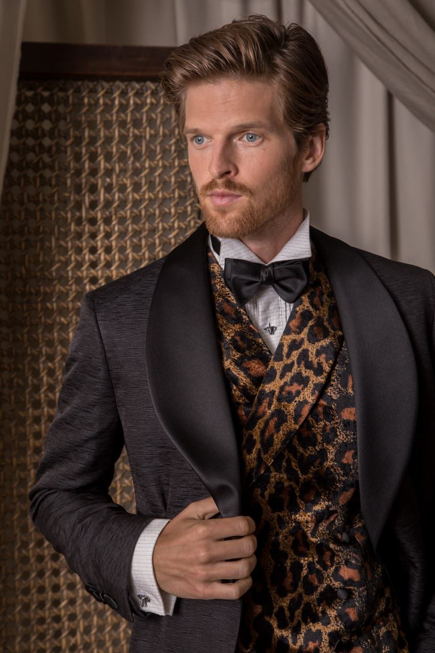 Male model wearing a black tuxedo jacket with satin lapels, leopard print vest , black bowtie and patterned shirt, with Jan Leslie Elephant Head Mother  of Pearl & Enamel Sterling Silver Cufflinks & Tuxedo Studs 