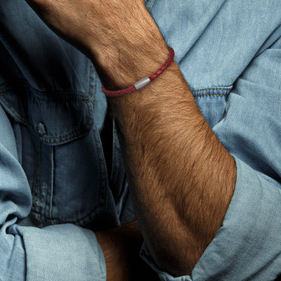 Close up of male models wrist donning the Red Braided Leather Magnetic Bracelet. 