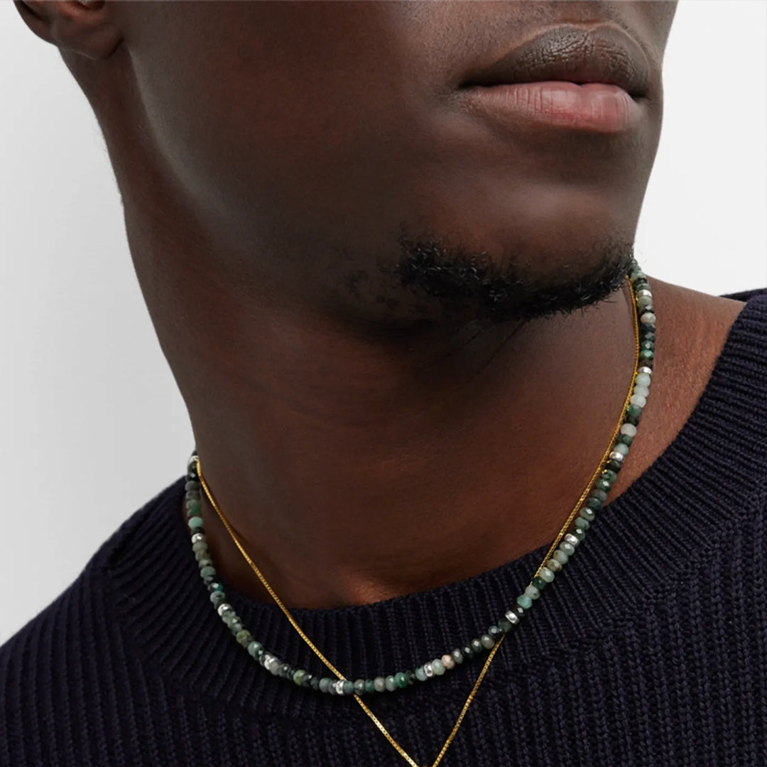 Close up of the neck of a male model wearing the Emerald Beaded Necklace with Sterling Silver Accents and Toggle Closure I Jan Leslie Cufflinks ad Accessories. 