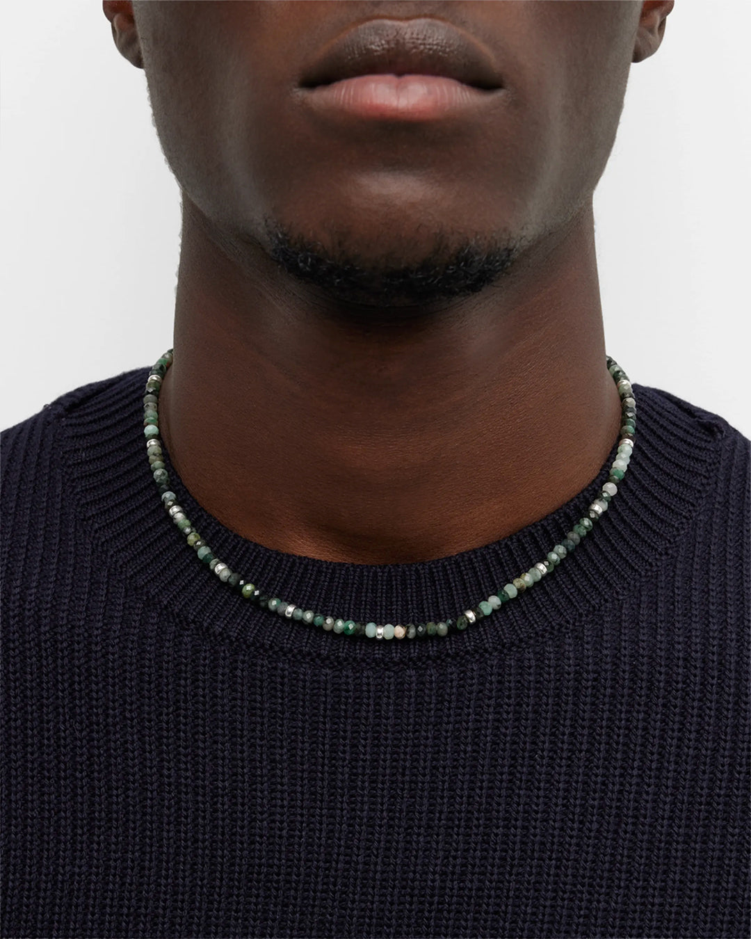 Close up of the Emerald Beaded Necklace with Sterling Silver Accents and Toggle Closure on male model. Necklace hits at collar. 