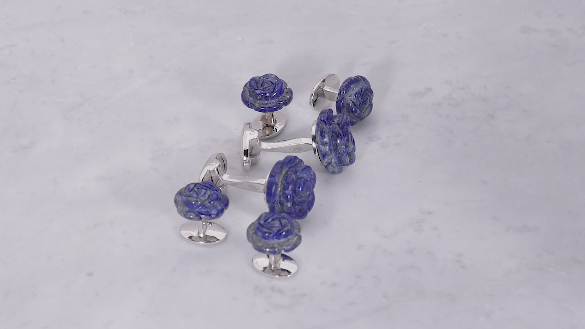 180 of Jan Leslie's Hand Carved Gemstone Rose Sterling Silver Cufflinks and Tuxedo Studs in lapis on a marble background. 